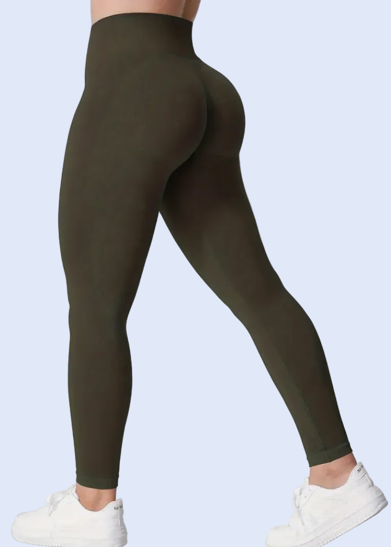 Person wearing olive green leggings and white sneakers on a white background