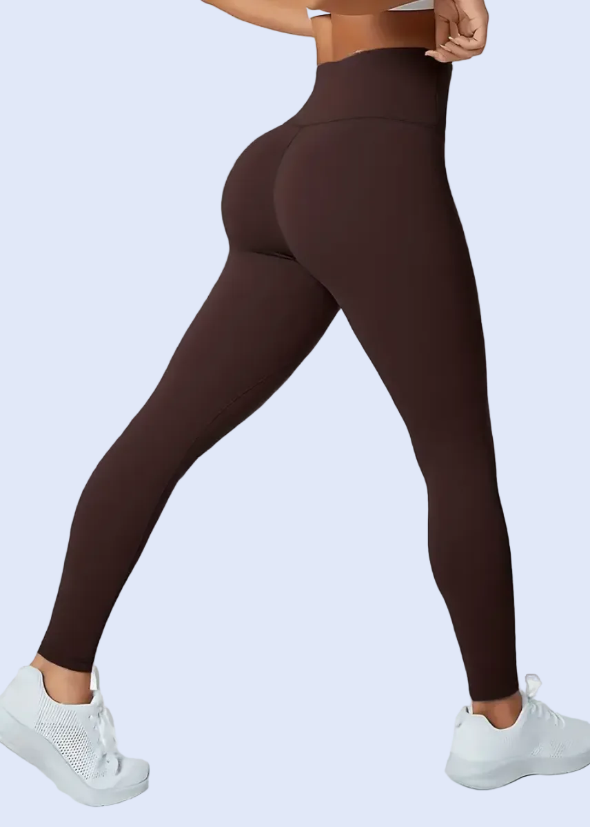 Person wearing brown leggings on a white background