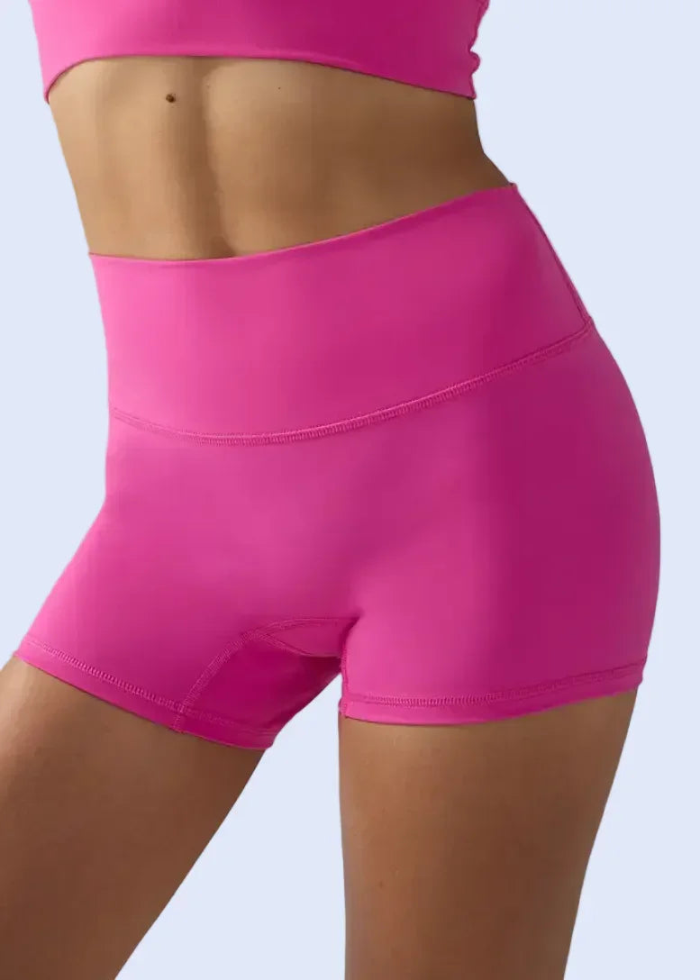 Person wearing bright pink athletic shorts and top on a gray background