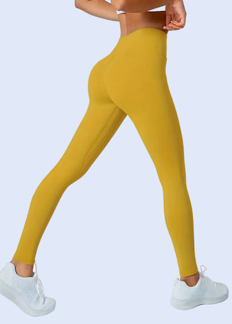 Mustard yellow leggings worn by a person on a white background