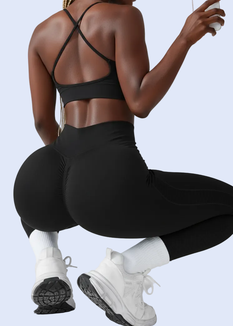 Person in black athletic wear taking a selfie on a gray background