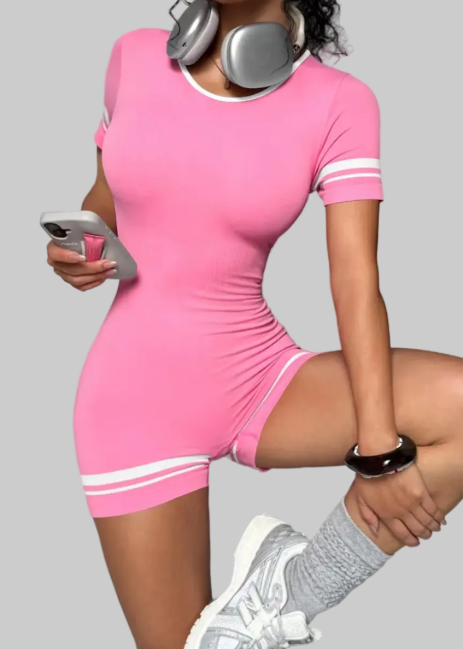 Person wearing a pink dress with white stripes on a gray background