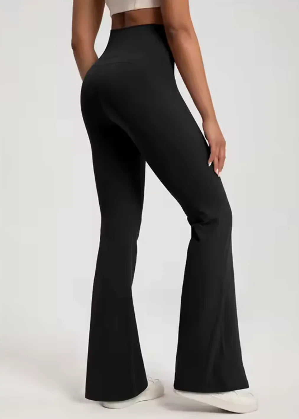 Woman wearing high-waisted black flared activewear pants from GymDeity