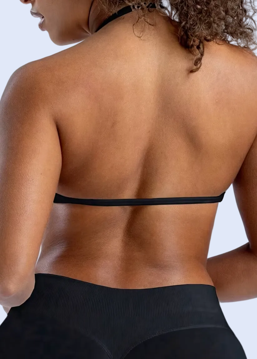 Person wearing a black sports bra and leggings on a white background