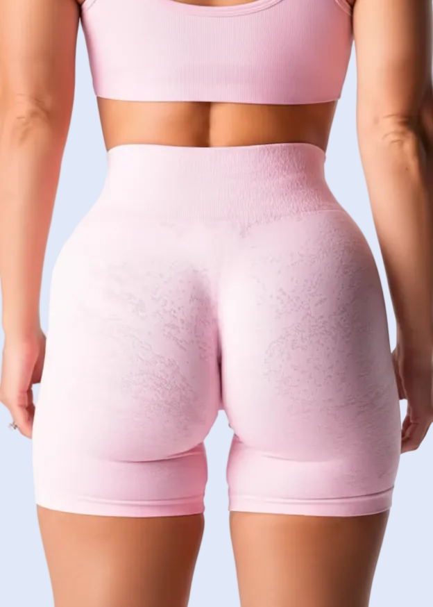 Pink athletic shorts worn by a person on a white background