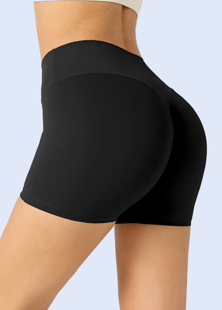 Black athletic shorts worn by a person on a plain background