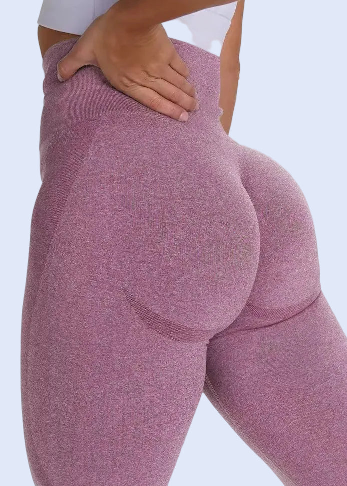 Person wearing a pair of pink leggings on a white background
