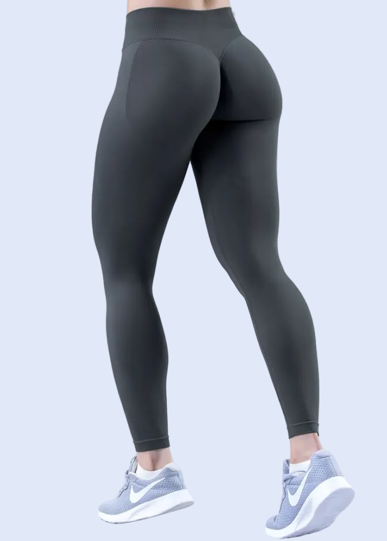 Person wearing black leggings and white sneakers on a light gray background