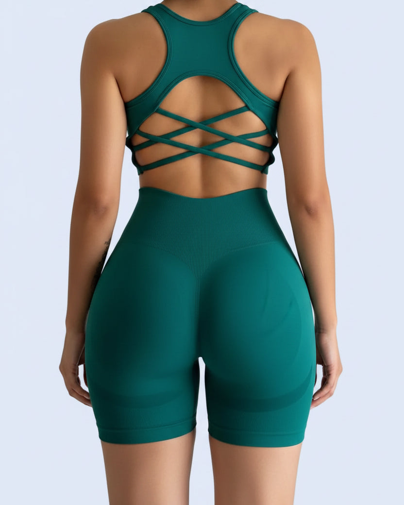 Person wearing a green sports outfit with criss-cross back design on a plain background