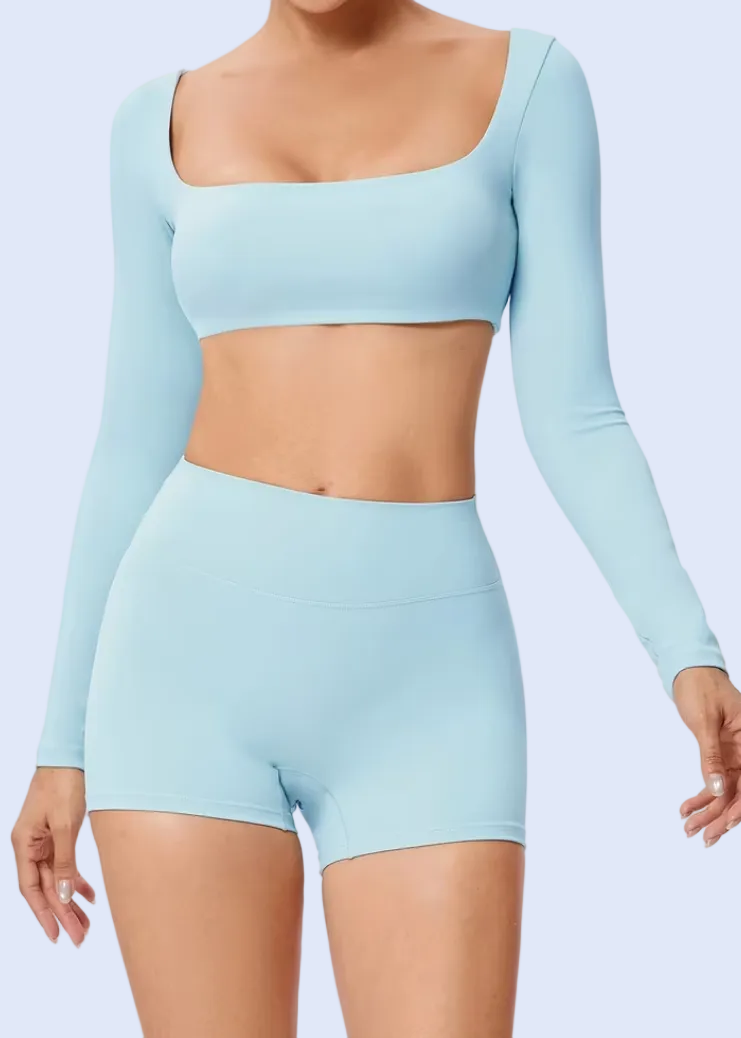 Light blue athletic outfit with long-sleeve top and shorts on a white background