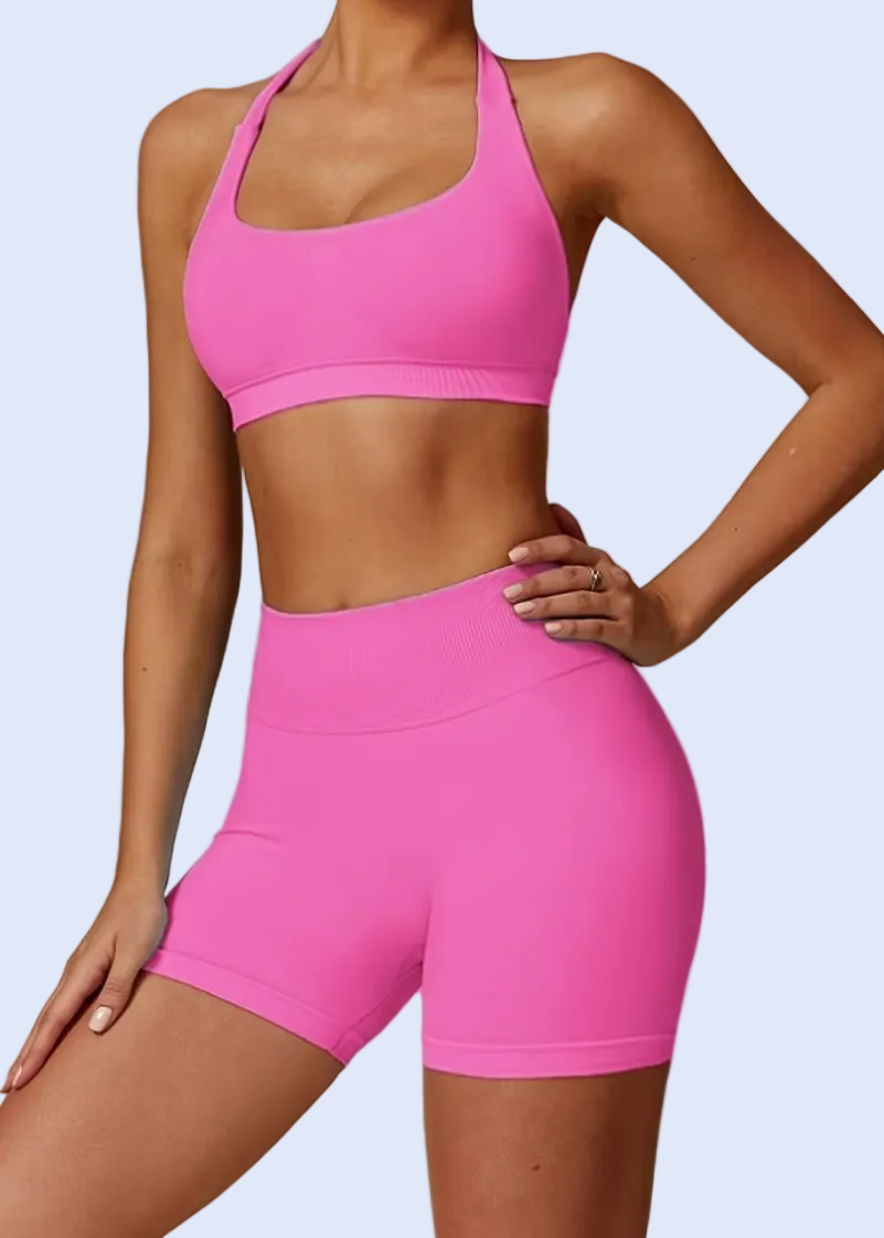 Person wearing a pink sports bra and shorts on a gray background