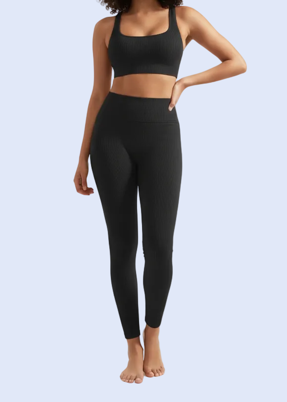 Woman wearing a black athletic outfit on a white background