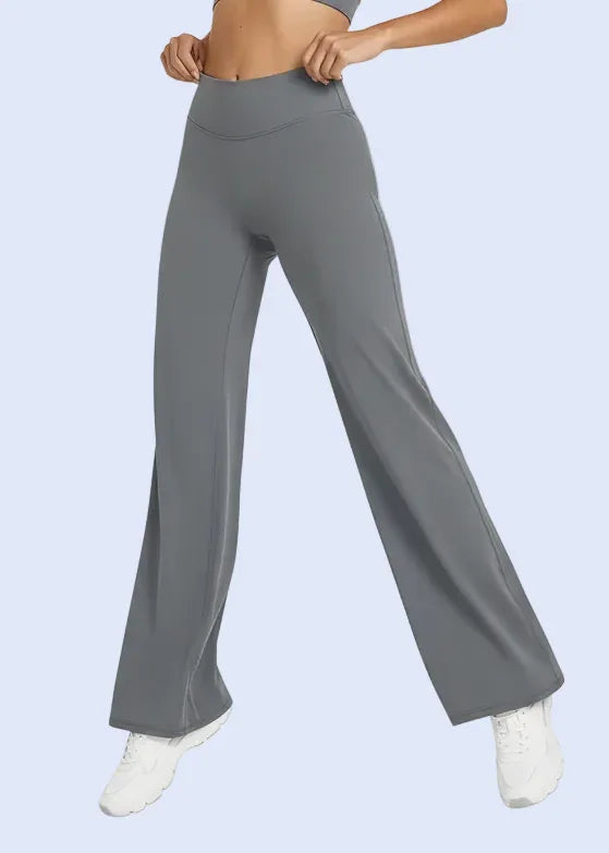 Person wearing gray flared pants on a white background