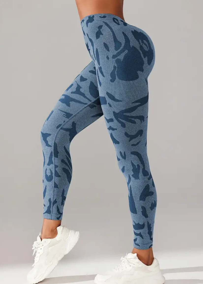 Blue camouflage leggings worn by a person on a gray background