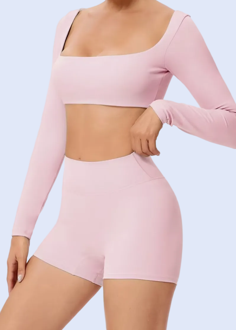 Person wearing a pink long-sleeve top and shorts on a white background