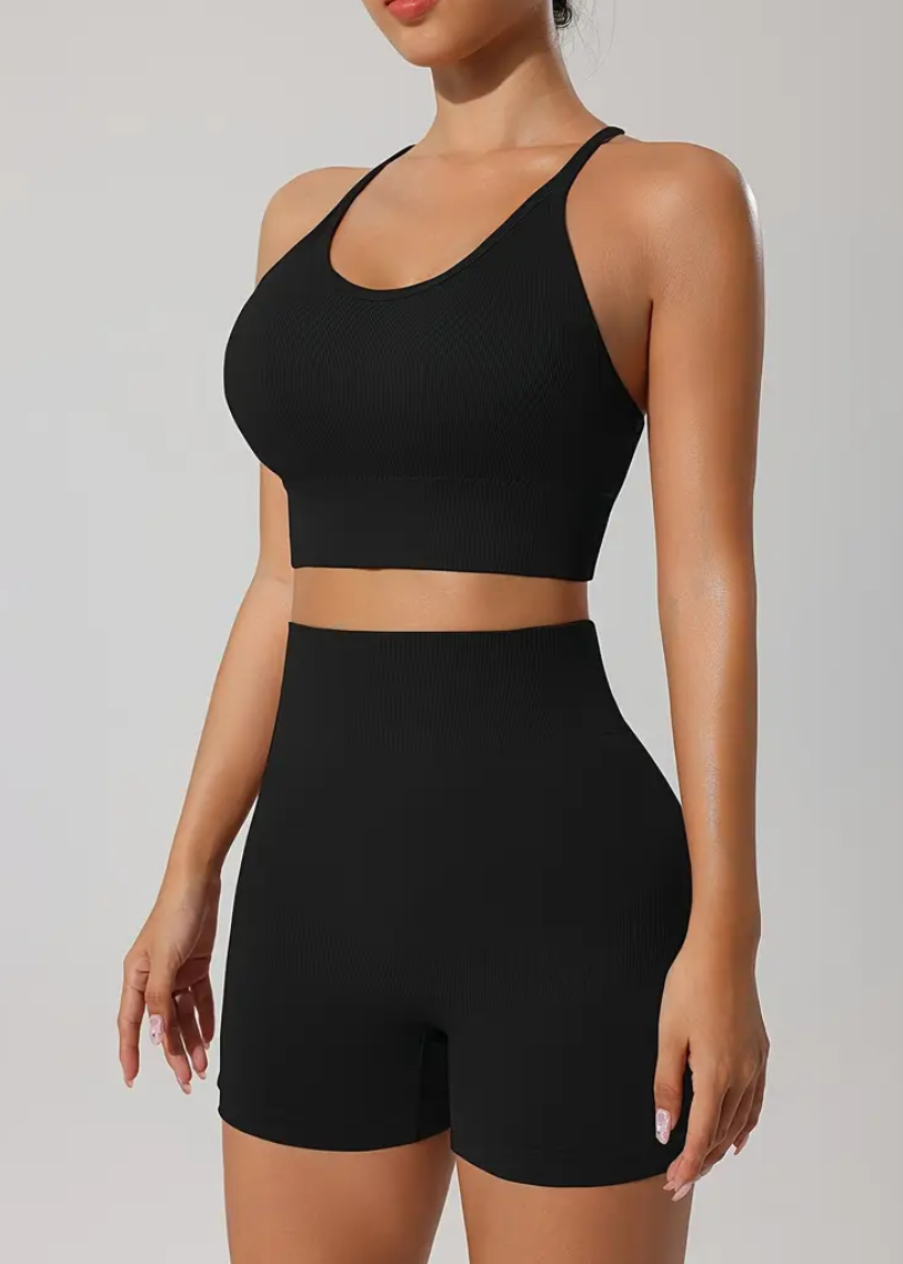 Person wearing a black athletic outfit on a plain background