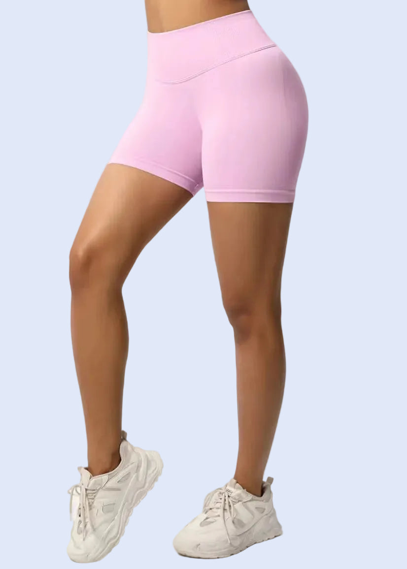 Person wearing pink athletic shorts on a white background