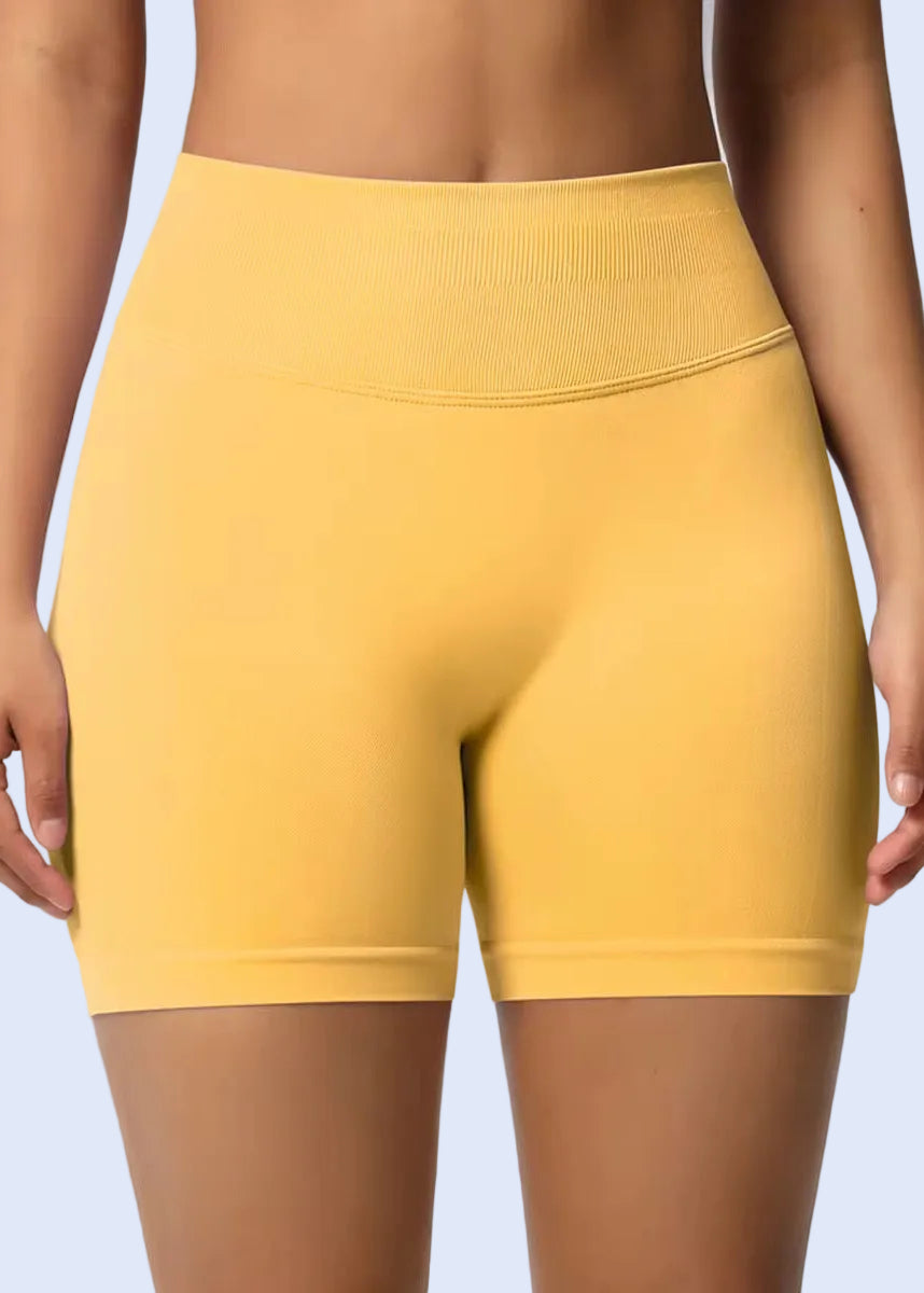 Yellow athletic shorts worn by a person on a plain background