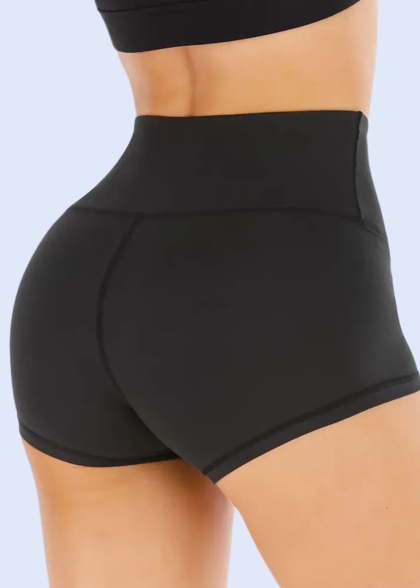 Black high-waisted shorts worn by a person on a white background