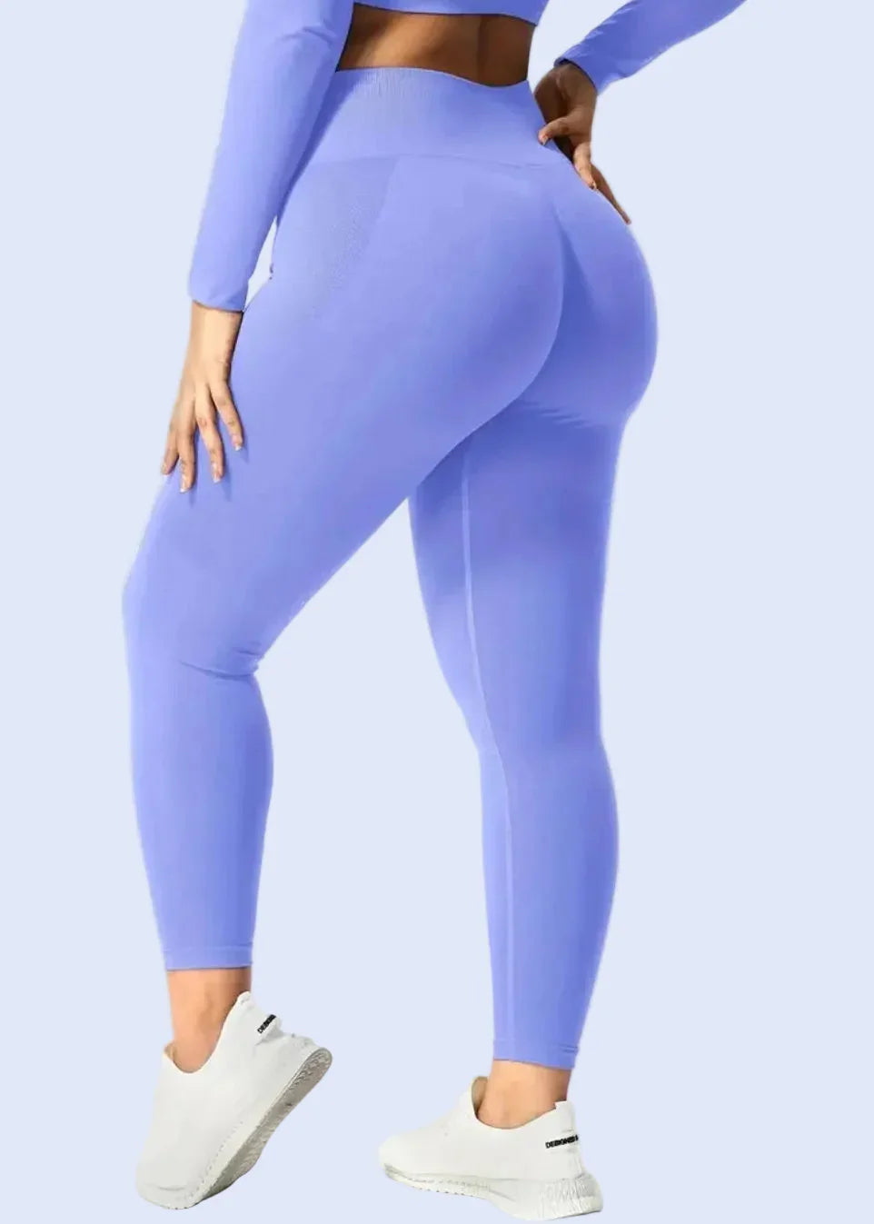 Woman modeling purple seamless activewear leggings and matching top from GymDeity