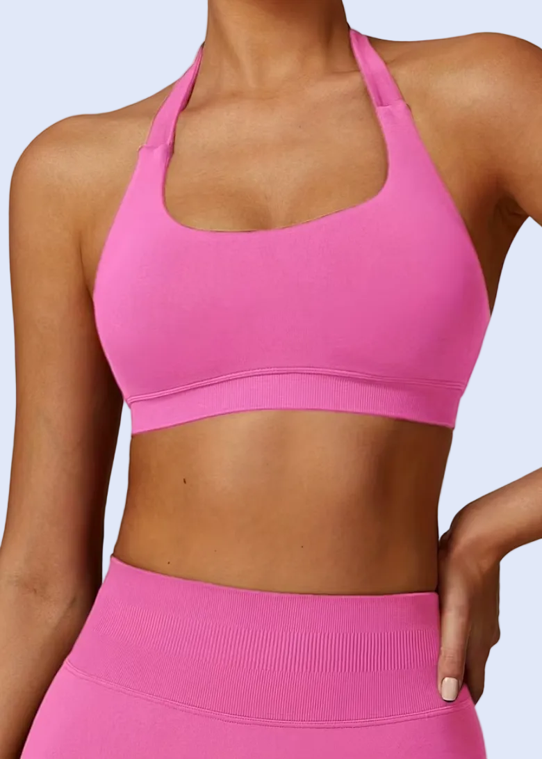 Person wearing a pink sports bra and leggings on a plain background