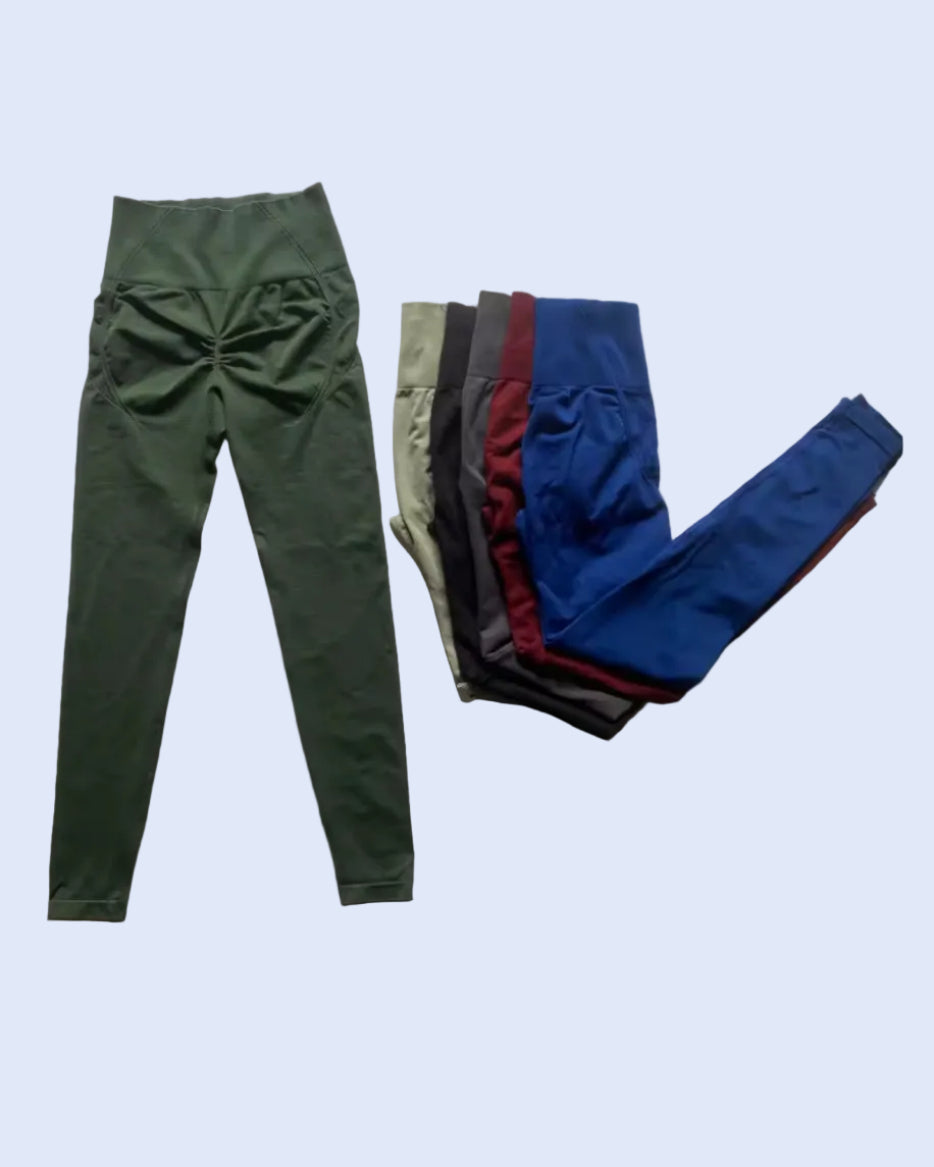 A pair of high-waisted ruched leggings in olive green is displayed next to a stack of folded leggings in multiple colors (olive green, black, burgundy, and royal blue) on a plain white background.