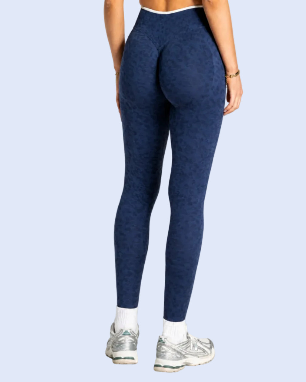 Person wearing navy blue patterned leggings with a white background