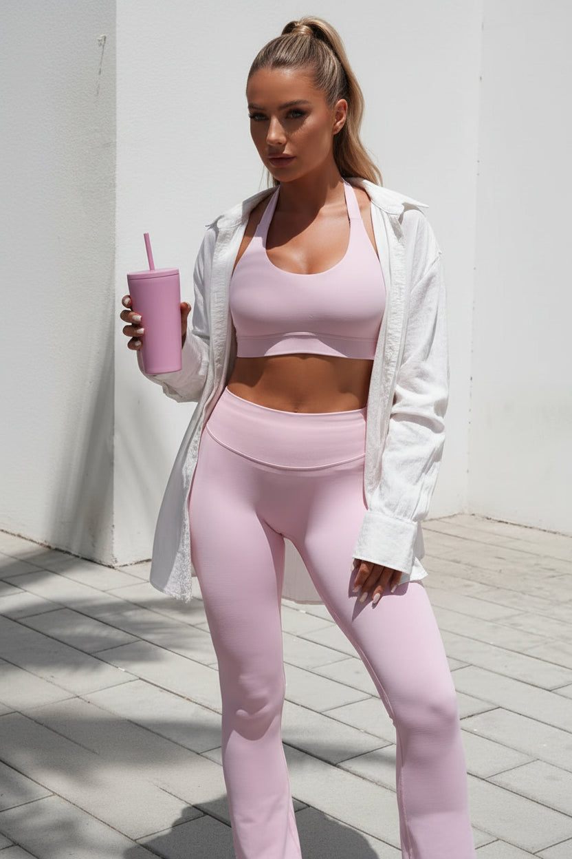Person wearing a pink athletic outfit holding a pink drink.