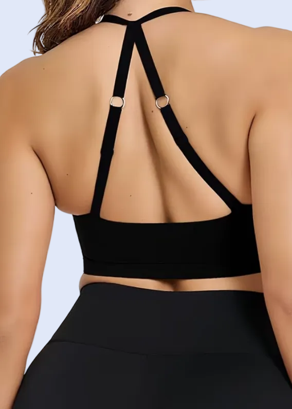 Person wearing a black sports bra and leggings on a plain background