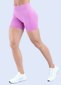 Person wearing pink athletic shorts and white sneakers on a light gray background