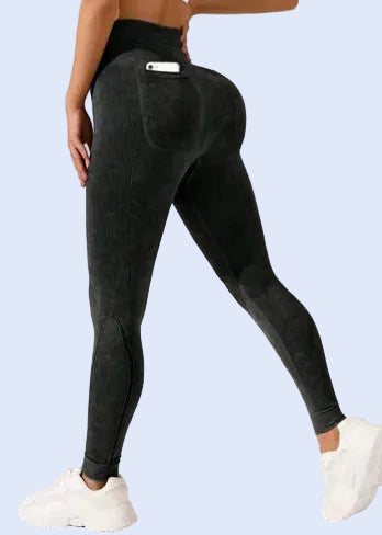 Person wearing black leggings on a plain background