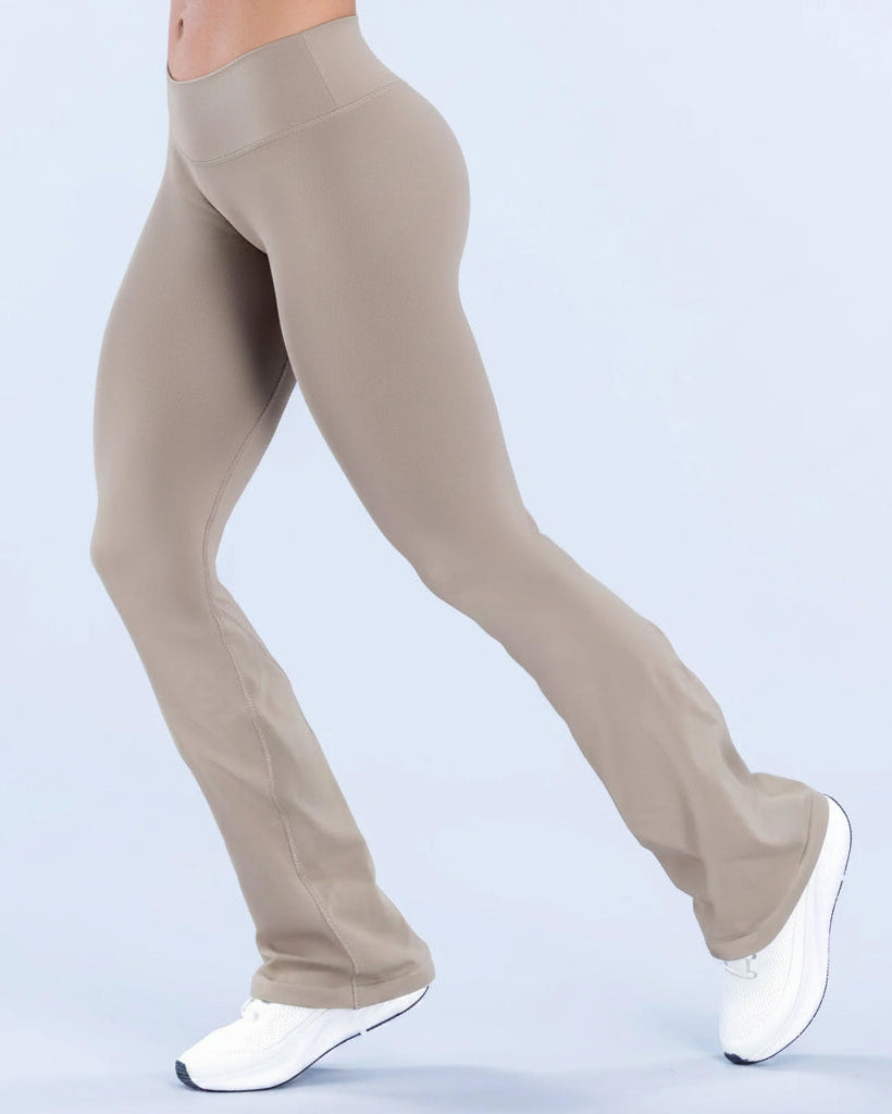 Beige yoga pants worn by a person on a light blue background