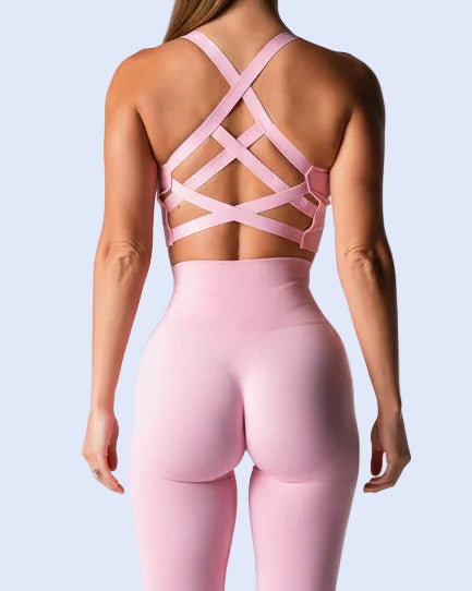 Person wearing a pink sports bra and leggings set on a light purple background