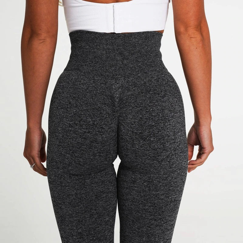 Person wearing dark gray high-waisted pants on a white background
