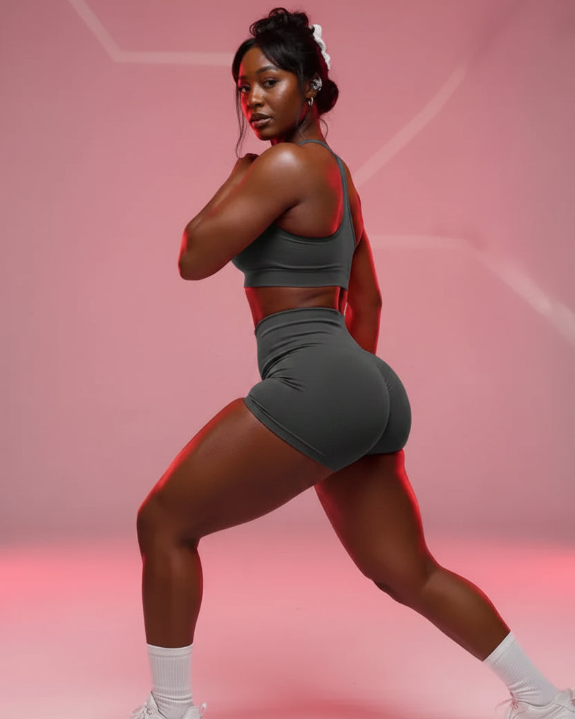 Person wearing a pink athletic outfit posing against a pink background