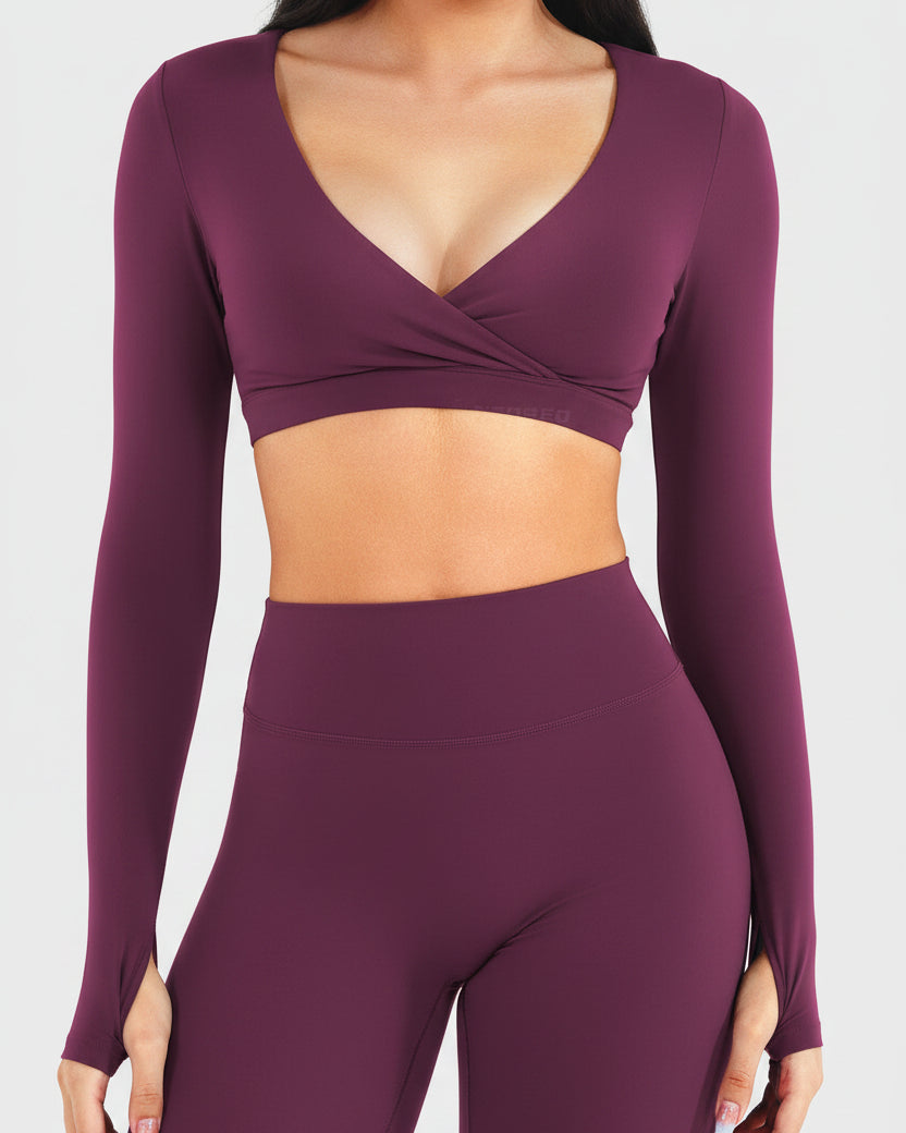 Purple long-sleeve sports bra and leggings set on a plain background