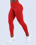 A person wearing bright red high-waisted leggings and white sneakers, shown from the waist down against a light blue studio background.