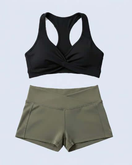 Black sports bra and olive green shorts on a light blue background