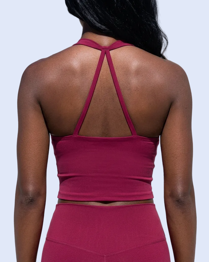 Straight-on back view of the dark-skinned model, focused on the burgundy halter tank top and open-back straps